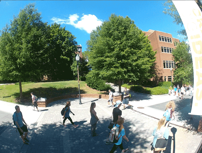 Gif of volunteers standing still while pedestrians pass them